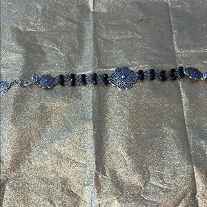 Sterling silver bracelet with silver designs each decorated with black beads.